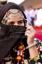 Image du Maroc Professionnelle de  Une jeune fille du désert pose en tenue traditionnelle durant le grand Moussem de Tan Tan. Ce grand rassemblement est organisé dans un site désertique sur lequel la ville de Tan Tan a toujours accueilli la majorité des tribus et des grandes familles nomades du désert lors d'un grand moussem, Samedi 18 septembre 2004. (Photo / Abdeljalil Bounhar)




